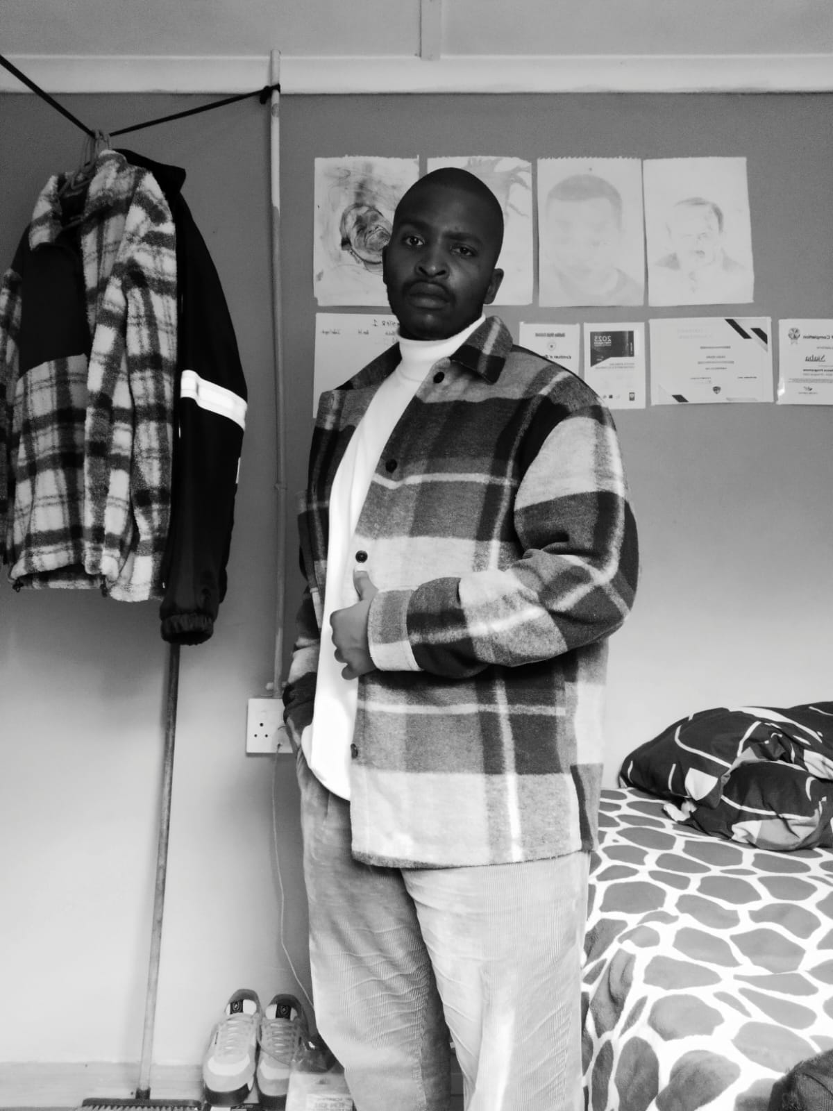 Zamamiya Njaba standing in a room in a black-and-white portrait